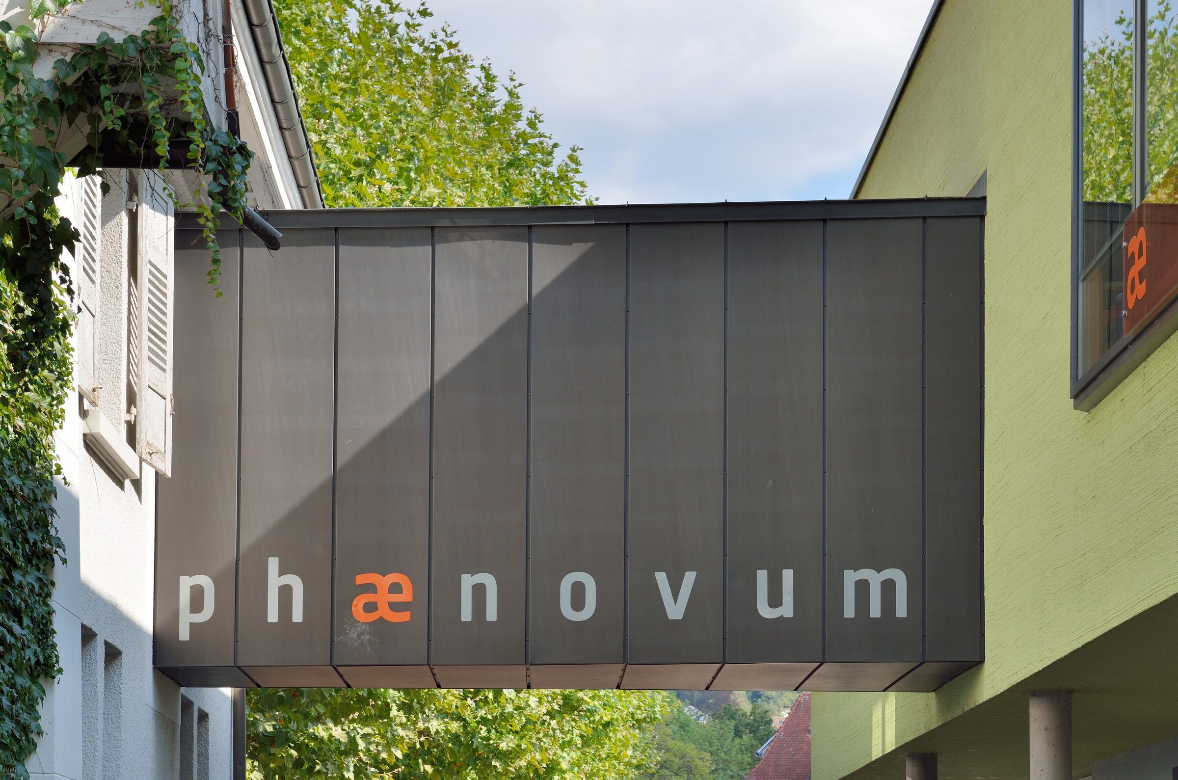 Das Gebäude des phænovum von der Straße aus, mit dem Schriftzug an der dunklen Fassade
